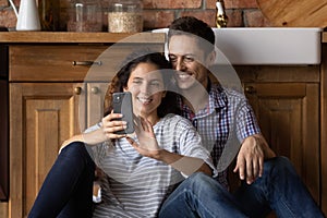Happy man and woman relax using cellphone at home