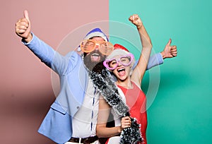 Happy man and woman wear santa hats and funny sunglasses. Christmas party office. Manager tinsel celebrate new year