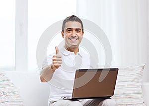 Happy man working with laptop computer at home