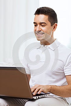 Happy man working with laptop computer at home