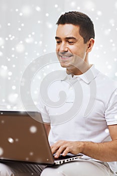 Happy man working with laptop computer at home