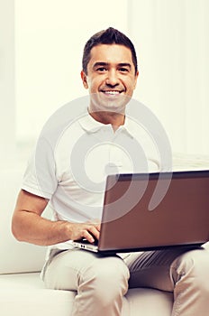 Happy man working with laptop computer at home