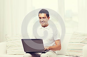 Happy man working with laptop computer at home