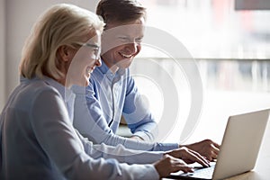 Happy manager and client having conversation at meeting with laptop