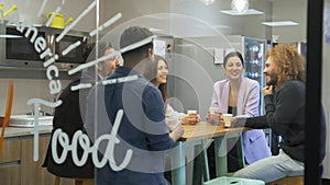 Happy manager talking to employees during coffee break in rest room