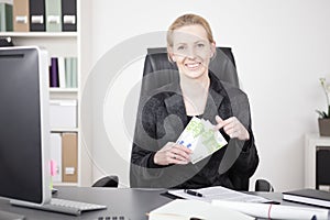 Happy Manageress at her Desk Holding a Fan of Cash photo