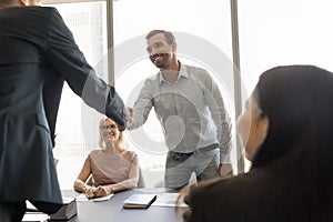 Happy managers men giving greeting handshake on team meeting