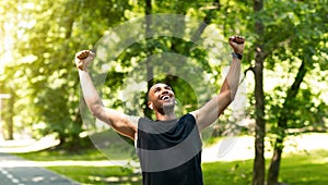 Happy marathon runner celebrating his victory or achievement during his training at park