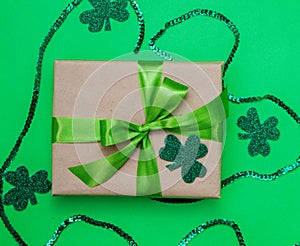 Happy March 17th. St. Patrick`s Day.Top view from above, a gift box wrapped in kraft paper, clover leaves