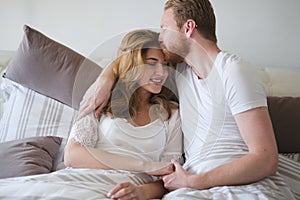 Happy married couple being romantic and sensual in bed