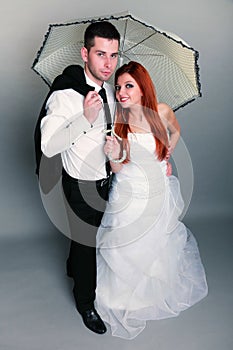 Happy married couple bride groom on gray background