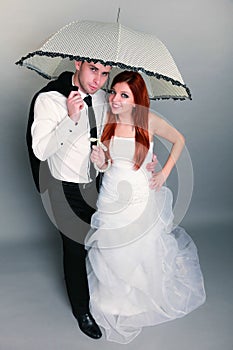 Happy married couple bride groom on gray background