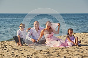 Happy married couple with children on their wedding anniversary day in their wedding dresses .