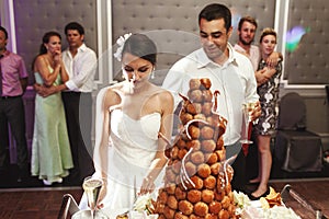 Happy married couple eating delicious chocolate wedding cake at