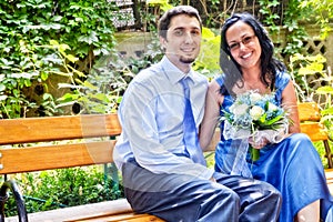 Happy married couple sitting on bench
