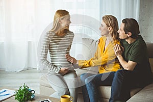 Happy married couple thanking pregnant woman for child