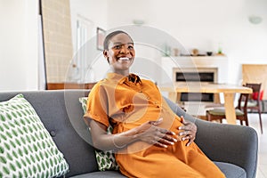 Happy mature african pregnant woman smiling at home