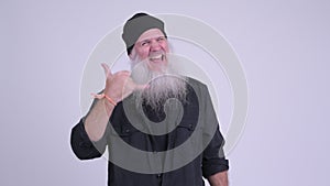 Happy mature bearded hipster man with call me gesture