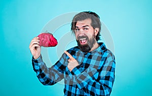 happy mature bearded hipster man holding purse with money, on blue background, finance