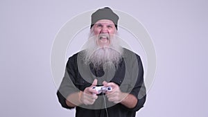 Happy mature bearded hipster man playing games and winning