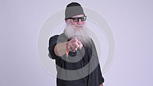 Happy mature bearded hipster man pointing at camera