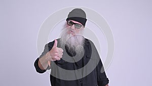 Happy mature bearded hipster man smiling and giving thumbs up