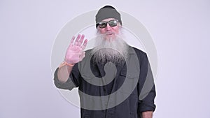 Happy mature bearded hipster man smiling while waving hand