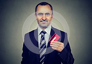 Happy mature business man offering new credit card