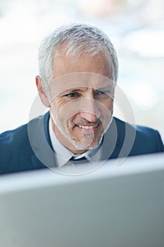 Happy, mature businessman and computer in office for email, connectivity and internet. Male ceo, corporate and