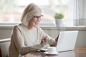 Happy mature businesswoman excited reading good news looking at