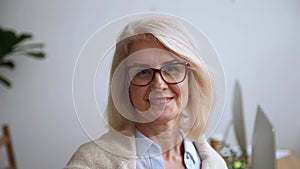 Happy mature businesswoman in glasses smiling looking at camera