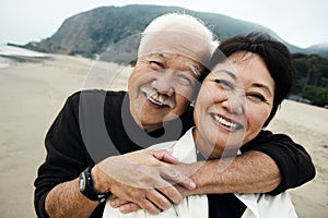 Happy Mature Chinese Couple Hugging on Beach