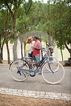 Happy mature couple with bikes meeting and kissing