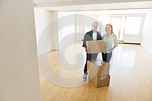 Happy Mature Couple With Cardboard Boxes In New House