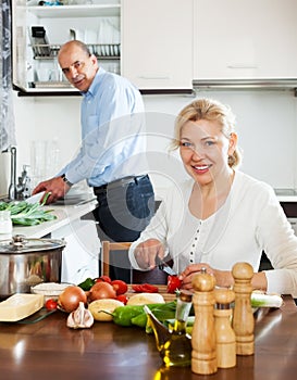 Happy mature couple cooking Spaniard tomatoes photo