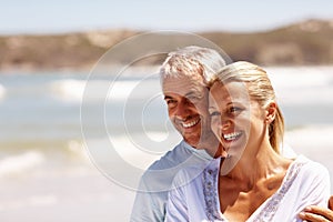 Happy mature couple embracing at the beach