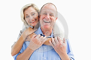 Happy mature couple embracing smiling at camera