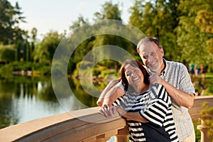 Happy mature couple in front of nature landscape.