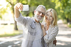 Happy Mature Couple Having Fun While Taking Selfie On Smartphone Outdoors