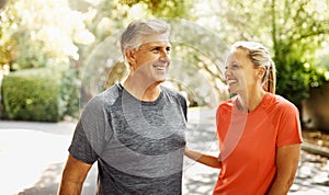 Happy mature couple keeping active, fit and healthy while jogging, running or going for walk outdoors in nature