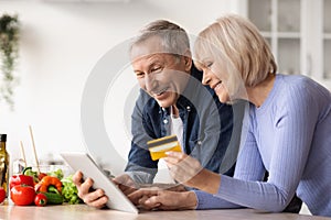 Happy mature couple making online order, using digital tablet