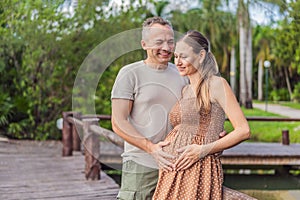 A happy, mature couple over 40, enjoying a leisurely walk in a park, their joy evident as they embrace the journey of