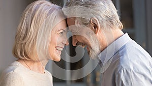 Happy mature couple touch foreheads enjoying romantic moment
