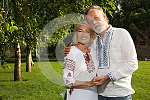 Happy mature couple in Ukrainian national clothes outdoors