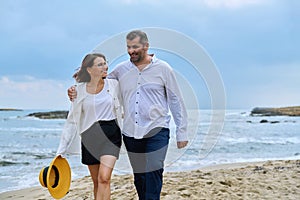 Happy mature couple walking on the beach