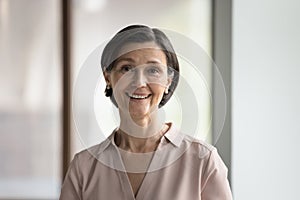 Happy mature female business leader head shot portrait