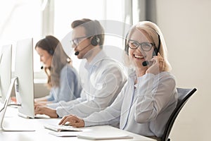 Happy mature female call center agent looking at camera smiling