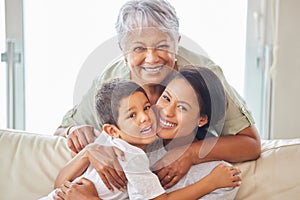 Happy mature grandmother relaxing with her grandson and adult daughter at home. Cheerful little hispanic boy sitting on