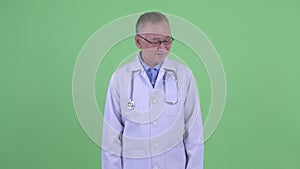 Happy mature Japanese man doctor relaxing with eyes closed