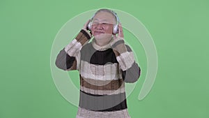 Happy mature Japanese man listening to music